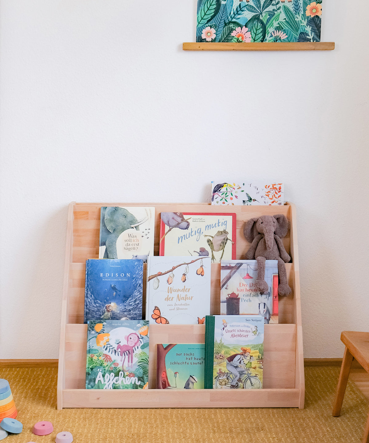 Bücherregal mit Bilderbüchern steht in Kinderzimmer.