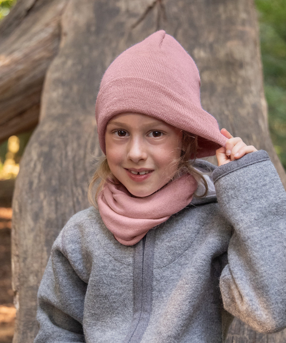 Mädchen mit Strickmütze und Schlauchschal in Rose.